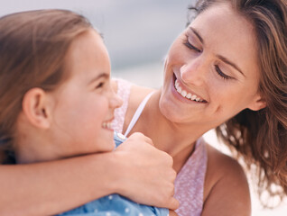 Canvas Print - Happy mother, child and hug with love at beach for support, care or bonding on outdoor holiday or weekend in nature. Face of mom and young daughter with smile for embrace by the ocean coast or sea