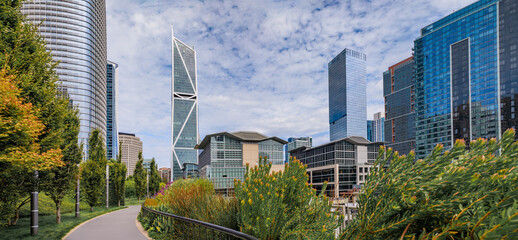 Wall Mural - Panoramic view of a downtown skyscrapers with trees and a path in a park in the SOMA neighborhood in San Francisco, California