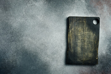 Wall Mural - Old Chopping Board on Gray Concrete Background. Creative photo, free space for text.