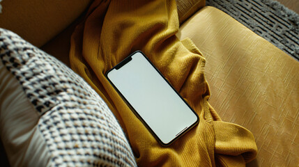 Isolated smartphone device on sofa at home with blank empty white screen, communication technology concept