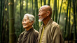 Elderly Asian couple in bamboo forest, radiant day, happily smiling, jackets worn.
