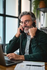 mature mid aged business man professional expert or entrepreneur making phone call speaking with client communicating on cellphone using laptop computer sitting at desk in office, Generative AI