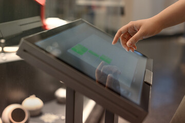 girl uses touchscreen terminal