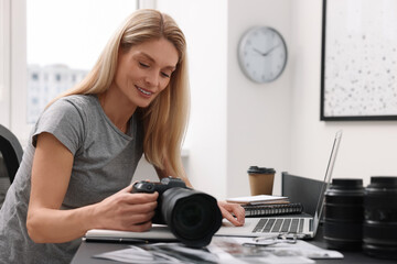 Canvas Print - Professional photographer with digital camera at table in office