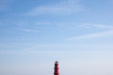 View Of The Red Lighthouse Top Against The Blue Sky At The Harbor