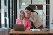 © Parichat - Two businesswomen working together at a boardroom during a meeting in a modern office.