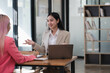 © Parichat - Two businesswomen working together at a boardroom during a meeting in a modern office.