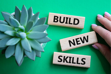 Build New skills symbol. Concept word Build New skills on wooden blocks. Businessman hand. Beautiful green background. Business and Build New skills concept. Copy space