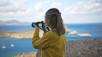 Wall Mural - Woman photographer takes pictures of Lindos Bay.