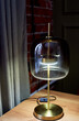 An interesting designer lamp on a golden base with thick glass. English style. Classic interior