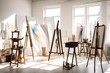 A minimalist artist's studio with white walls, a large easel, and organized art supplies in a sunlit space
