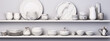 3D rendering of white and marble kitchenware on white shelves against a gray background.