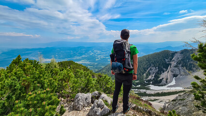 Wall Mural - Hiker man looking at alpine valley on way to mountain peaks Feistritzer Spitze (Hochpetzen), Karawanks, Carinthia, Austria. Wanderlust Austrian Alps. Hiking trail on Petzen, Bleiburg, Völkermarkt