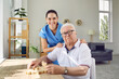 © Studio Romantic - Elderly man with friendly caregiver solving puzzles as memory training against Alzheimer's and dementia. Portrait of senior man and young smiling nurse in modern specialized nursing home.