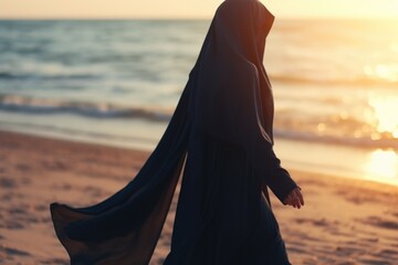 Poster - A woman enjoying a peaceful walk on the beach at sunset. Suitable for travel and relaxation concepts