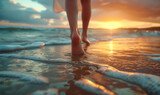 Fototapeta Góry - Low angle view of girls feet walking on beach at sunset