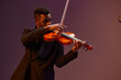 © SHOTPRIME STUDIO - Man in suit playing violin on stage with microphone in front of him during performance