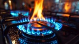 Fototapeta Zachód słońca - An industrial resource and economics notion is shown in this close-up of a blue fire blazing on the stovetop of a residential kitchen gas burner.