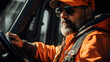 hardhatted man driving a truck with orange headwear 