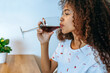 Woman drinking wine at home.