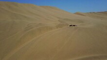 Desert Sand Dunes With People And A Buggy At Huacachina, Peru. Aerial Drone Shot.