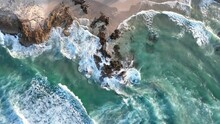 Top Down Descending Shot Of Stradbroke Islands Rocky Coast Line. Waves Hitting The Rocks, Golden Hour Shot Of Waves Crashing Into Rocks In Slow Motion Drone Shot. 4K QLD Australia Tourism