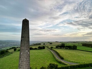 Wall Mural - Aerial shot of a majestic monument standing in the middle of a lush, green field.