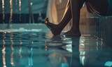 Fototapeta  - Closeup of female legs standing in swimming pool with reflection on water