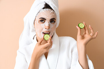 Wall Mural - Pretty young woman with facial sheet mask and cucumber slices on beige background