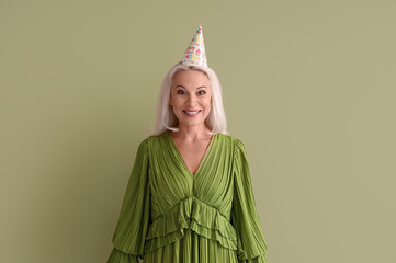 Poster - Mature woman in party hat on green background