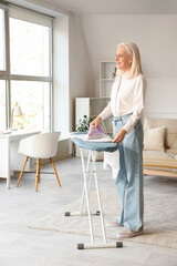 Poster - Happy mature woman ironing clothes at home