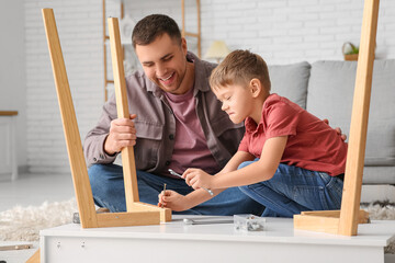 Canvas Print - Happy father and his little son assembling table at home