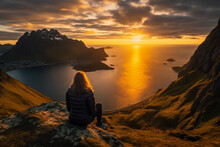Aerial view of a woman watching the sunset on the picturesque mountain beach