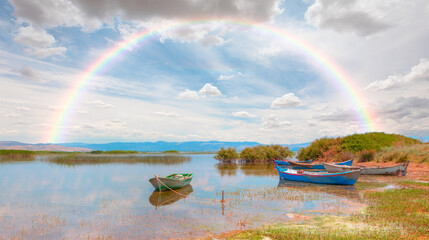 Wall Mural - Marmara lake with lot of sandal (Boat) amazing rainbow in the background - Manisa, Izmir