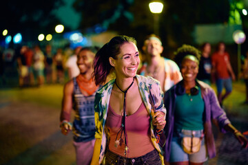 Wall Mural - Happy woman and her friends on summer music festival at night.