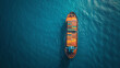 An aerial snapshot of a massive cargo ship navigating through the blue waters illustrating the scale of maritime trade.