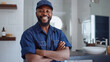 © VLA Studio - smiling man with a beard, wearing a blue plumber's uniform and cap, standing with his arms crossed in a modern bathroom