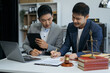 © NINENII - Teamwork of business lawyer meeting working hard about legal legislation in courtroom to help their customer...