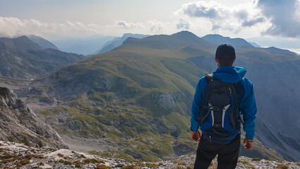 Wall Mural - Hiker man looking at majestic mountain peaks of Hochschwab massif, Styria, Austria. Idyllic hiking trail on high altitude alpine terrain, remote Austrian Alps in summer. Sense of escape. Nature lover