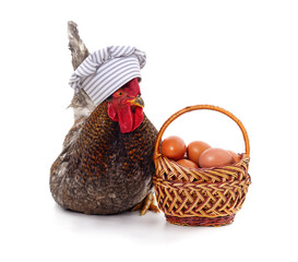 Poster - Chicken in a chef's hat near a basket with eggs.