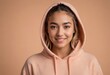 A smiling young woman in a casual hoodie, her friendly expression invites warmth and comfort. Her relaxed posture suggests ease and approachability.