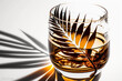 Elegant whiskey glass basking in light, casting a dynamic shadow