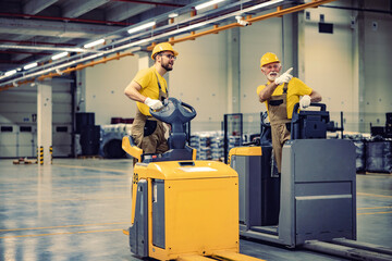 Wall Mural - Workers driving electric forklift at workplace