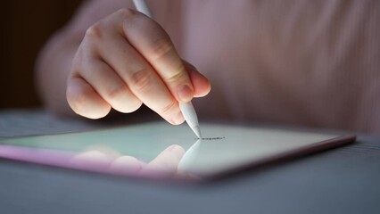 Close-up unrecognizable female hands using stylus writing on digital tablet. Concept of signature electronic document signing via digital tablet. Businesswoman putting electronic signature on notepad