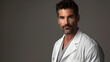 © Zape - handsome male doctor in his 40s facing forward wearing a doctor’s white coat, professional photography,