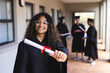 © Wavebreak Media - Teenage biracial girl proudly displays her diploma at graduation