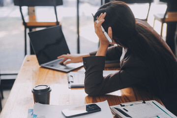 Asian women are stressed while working on laptop, Tired asian businesswoman with headache at office, feeling sick at work, copy space