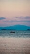 Rybak na łodzi Tajlandia Koh Chang wyspa, łowienie ryb na oceanie z widokiem na góry o zachodzie słońca
