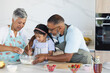 © Wavebreak Media - Biracial grandparents and granddaughter enjoy baking together in a modern home kitchen