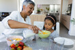 © Wavebreak Media - Biracial grandmother serves breakfast to a biracial granddaughter at home